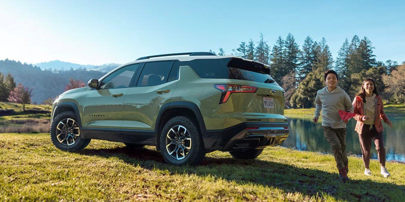 Chevrolet Equinox parked in the field while two kids run around the field
