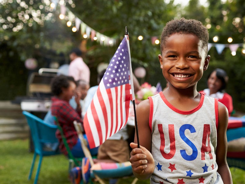 child with the american flag in hands smiling that the day is president's day