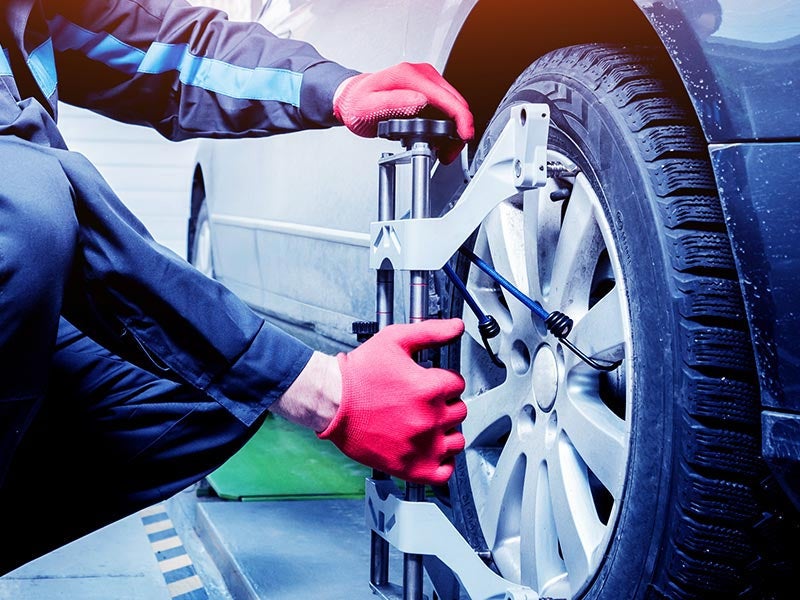 Mechanic performing a wheel alignment at Criswell Chevrolet GMC of Gaithersburg dealership
